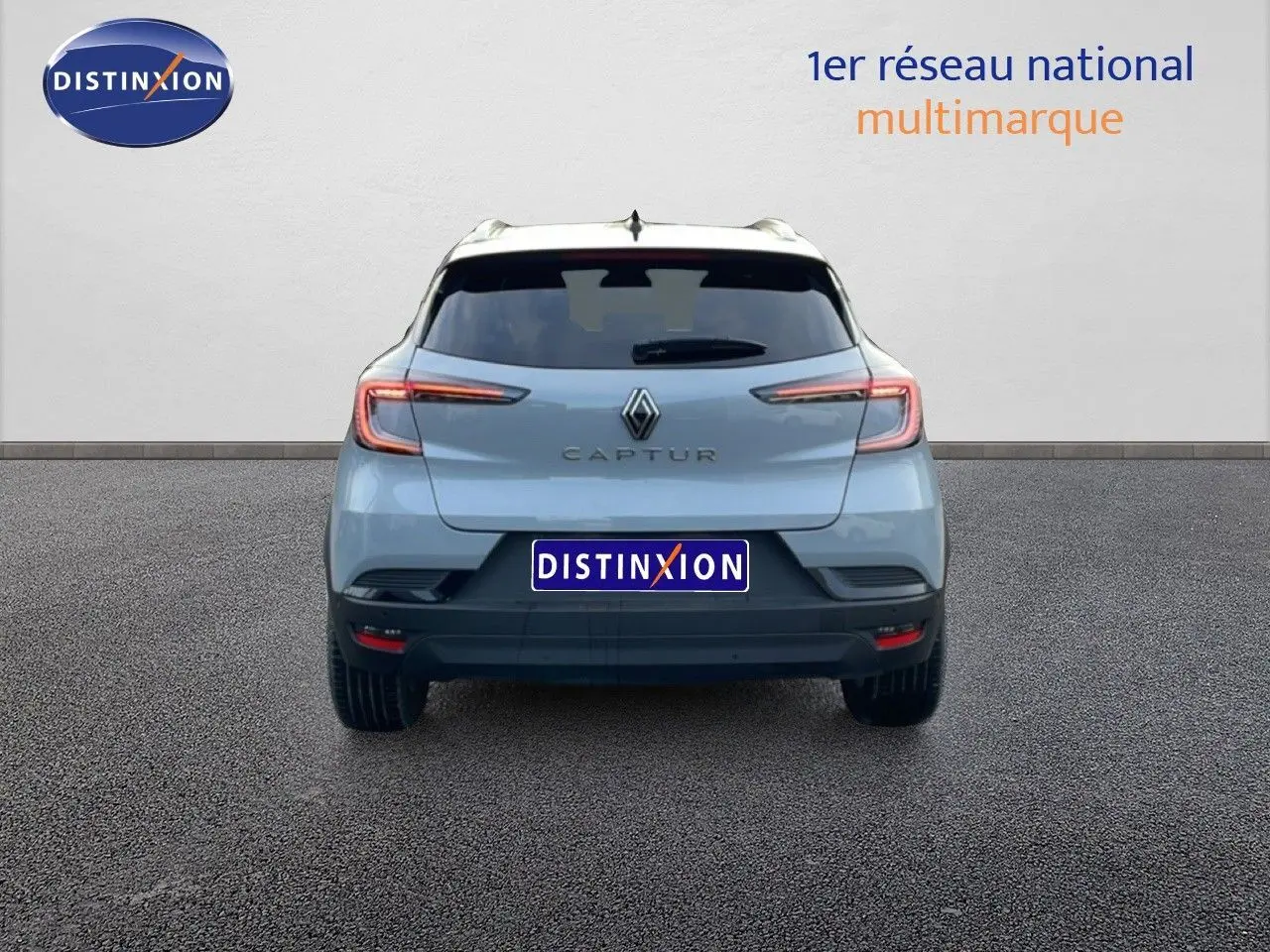 Vue arrière d'un Renault Captur 2025 gris Rafale métal avec toit noir, feux LED et plaque Distinxion visible.