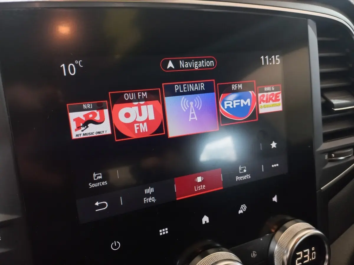 Écran tactile central de la Renault Mégane Business gris foncé, affichant les stations radio en vue rapprochée.