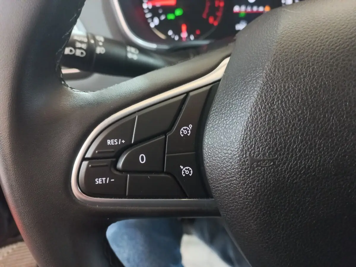 Gros plan sur les commandes du volant multifonctions noir de la Renault Mégane Business TCe 115 FAP 2022.