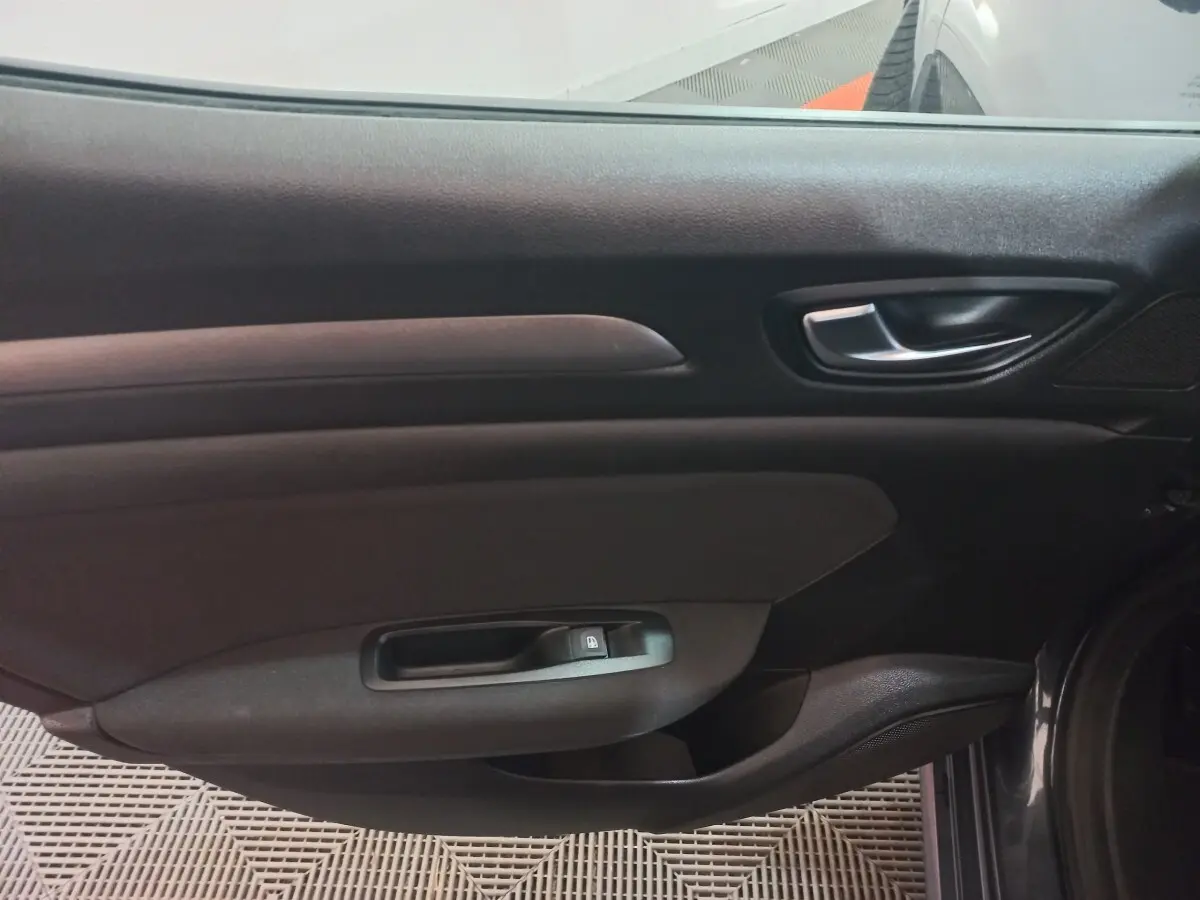 Vue intérieure côté droit de la porte avant gris foncé de la Renault Mégane Business TCe 115 FAP 2022 avec poignée et commande de vitre.