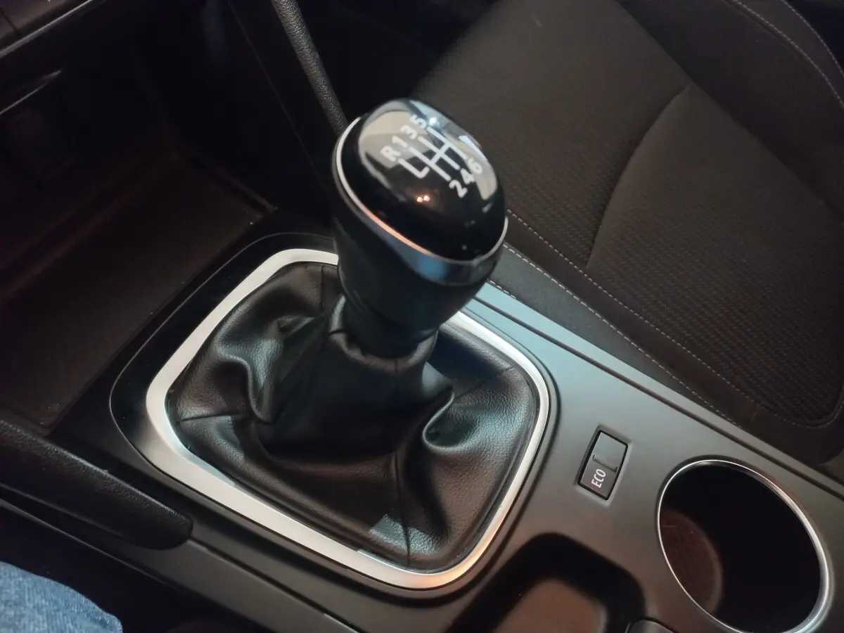 Gros plan sur le levier de vitesses manuel noir de la Renault Mégane Business gris foncé, avec bouton ECO à côté.