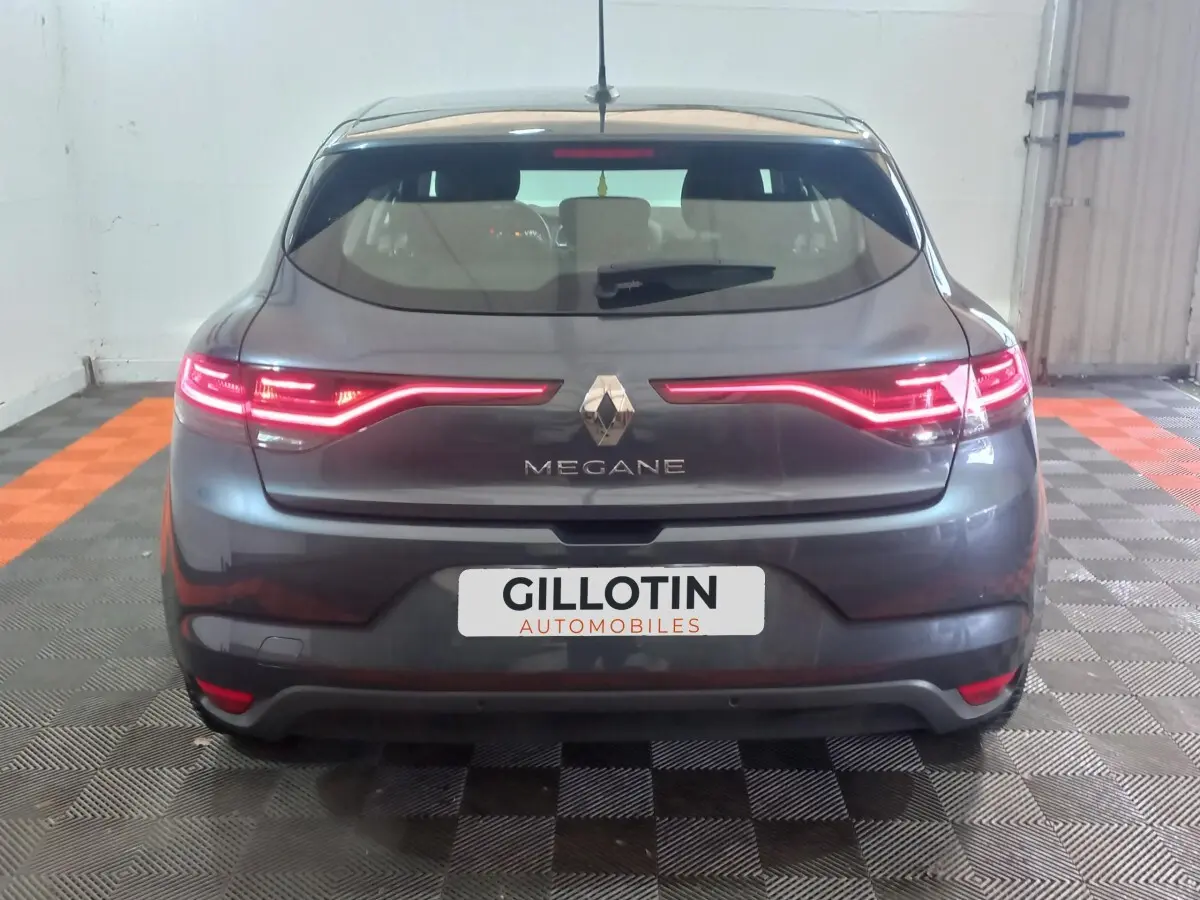 Vue arrière d'une Renault Mégane Business gris foncé avec feux LED allumés dans un garage.