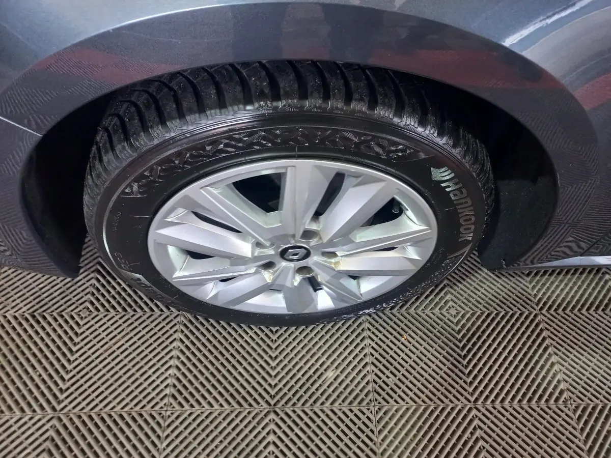 Gros plan sur la roue arrière droite grise foncée d'une Renault Mégane Business TCe 115 FAP avec jante argentée et pneu Hankook.
