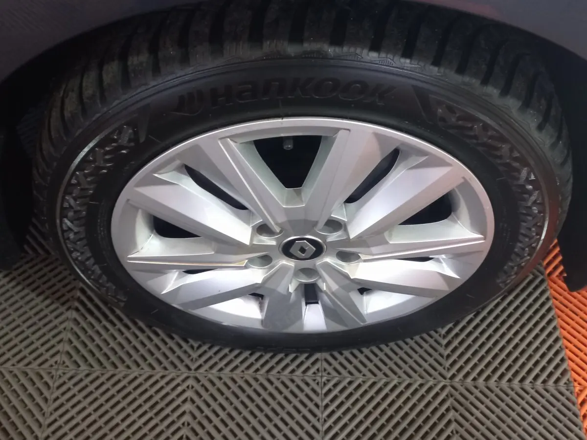 Gros plan sur la roue avant gauche de la Renault Mégane Business gris foncé avec jante alliage argentée et pneu Hankook.