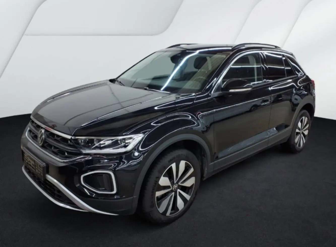 Volkswagen T-Roc noir en 3/4 avant droit, avec jantes distinctives et calandre chromée dans un studio blanc.