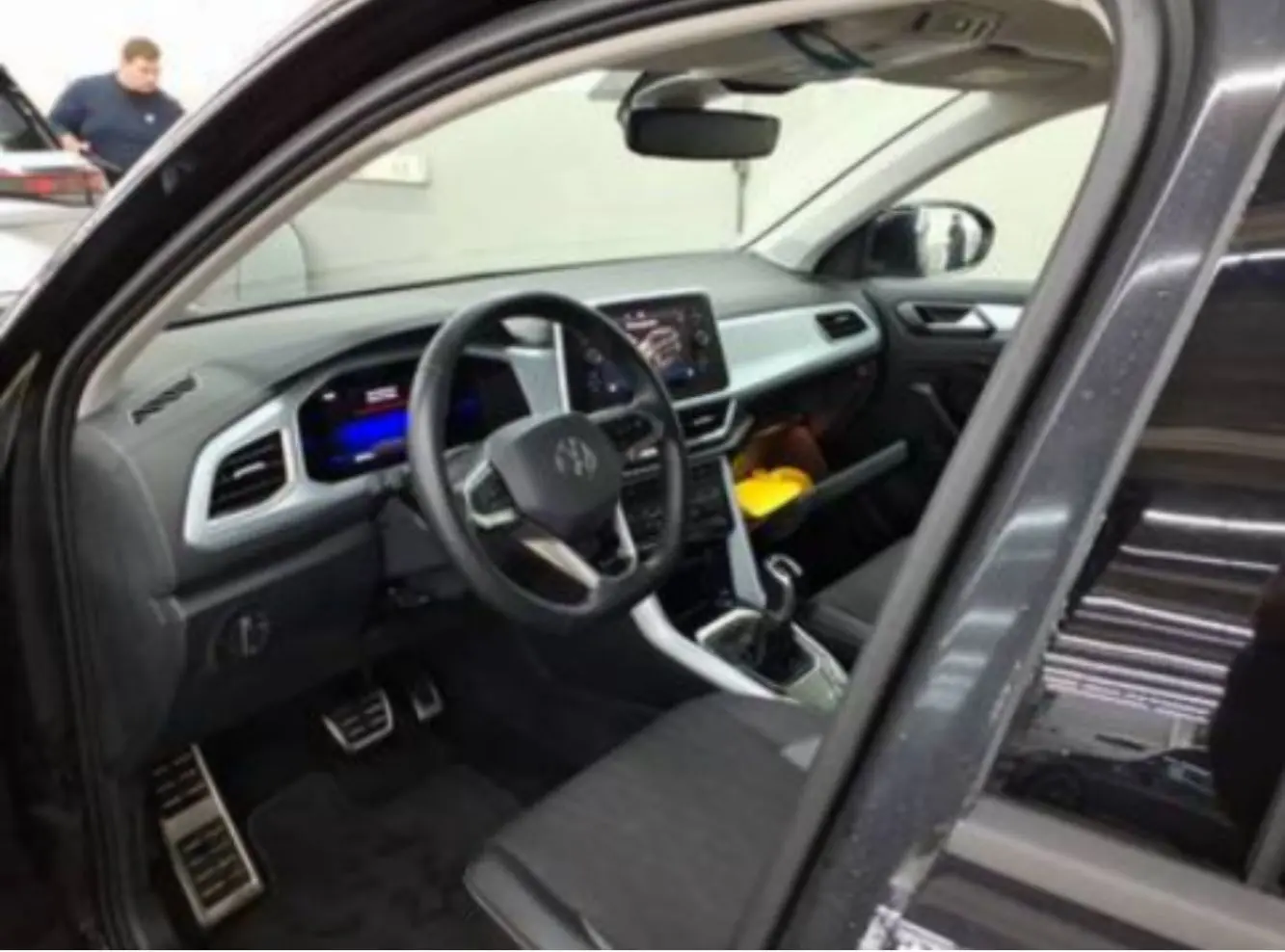 Intérieur noir du Volkswagen T-Roc 2025 vu côté conducteur, avec tableau de bord digital et écran tactile central.