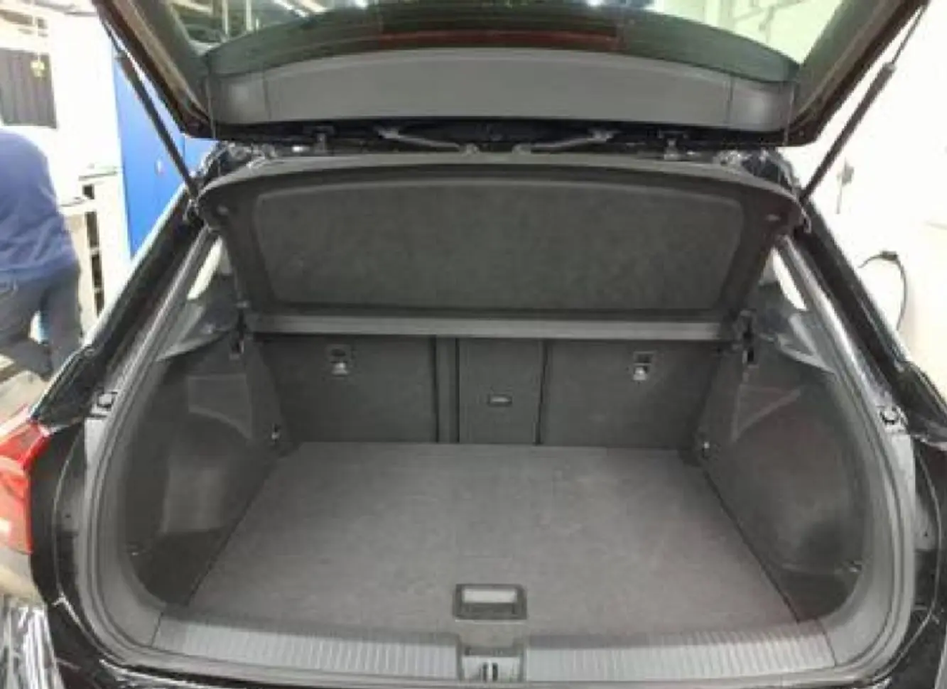 Coffre ouvert vu de l'arrière d'un Volkswagen T-Roc noir 2025, montrant un espace de chargement vide et propre.