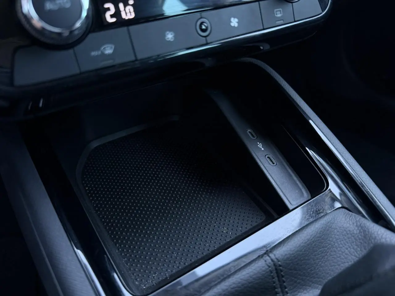 Gros plan sur la console centrale noire du Skoda Scala blanc, avec ports USB-C et commande de climatisation visible.