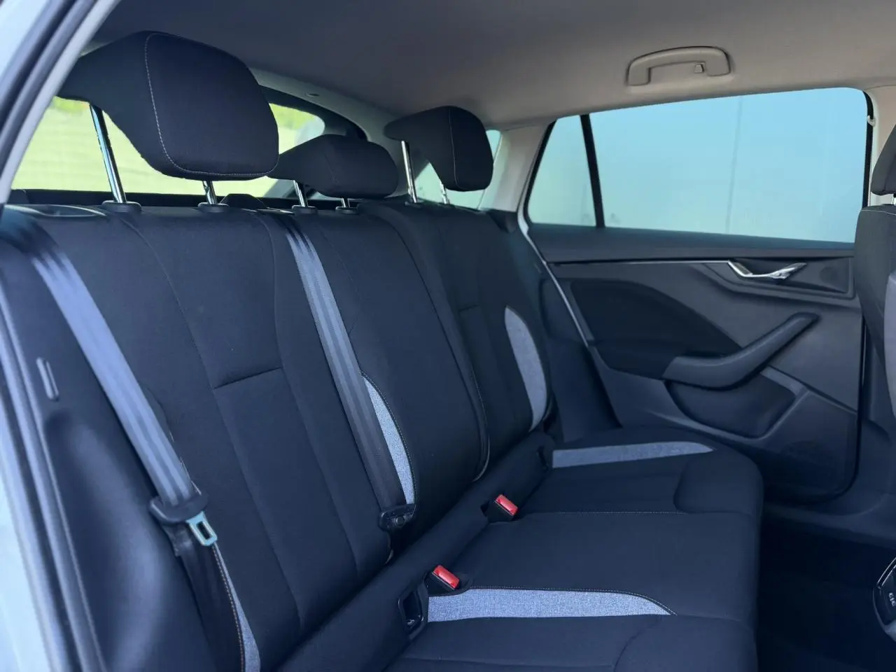 Vue intérieure côté gauche des sièges arrière noirs avec inserts gris d'une Skoda Scala TSI 116 Sélection 2025.