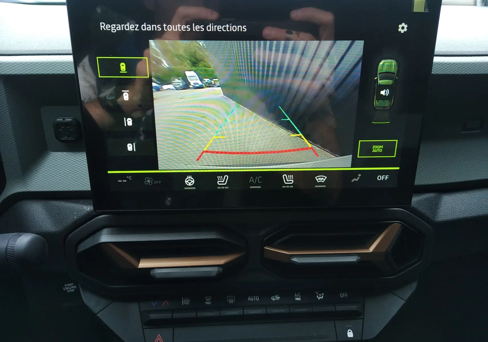 Écran central du Dacia Duster 2026 montrant la caméra de recul avec vue arrière et interface de contrôle climatisation.