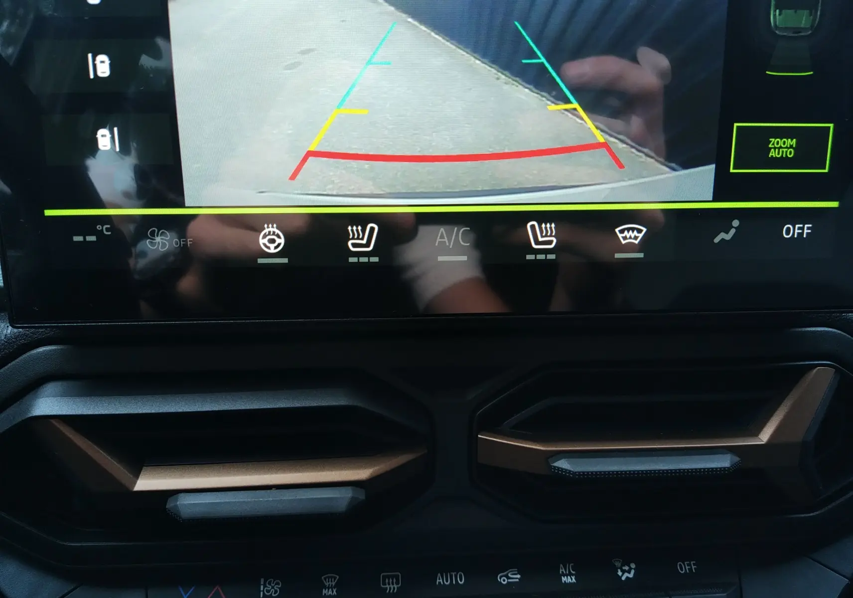 Vue rapprochée de l’écran tactile et des aérateurs couleur Sandstone du tableau de bord du Dacia Duster Hybrid-G 2026.