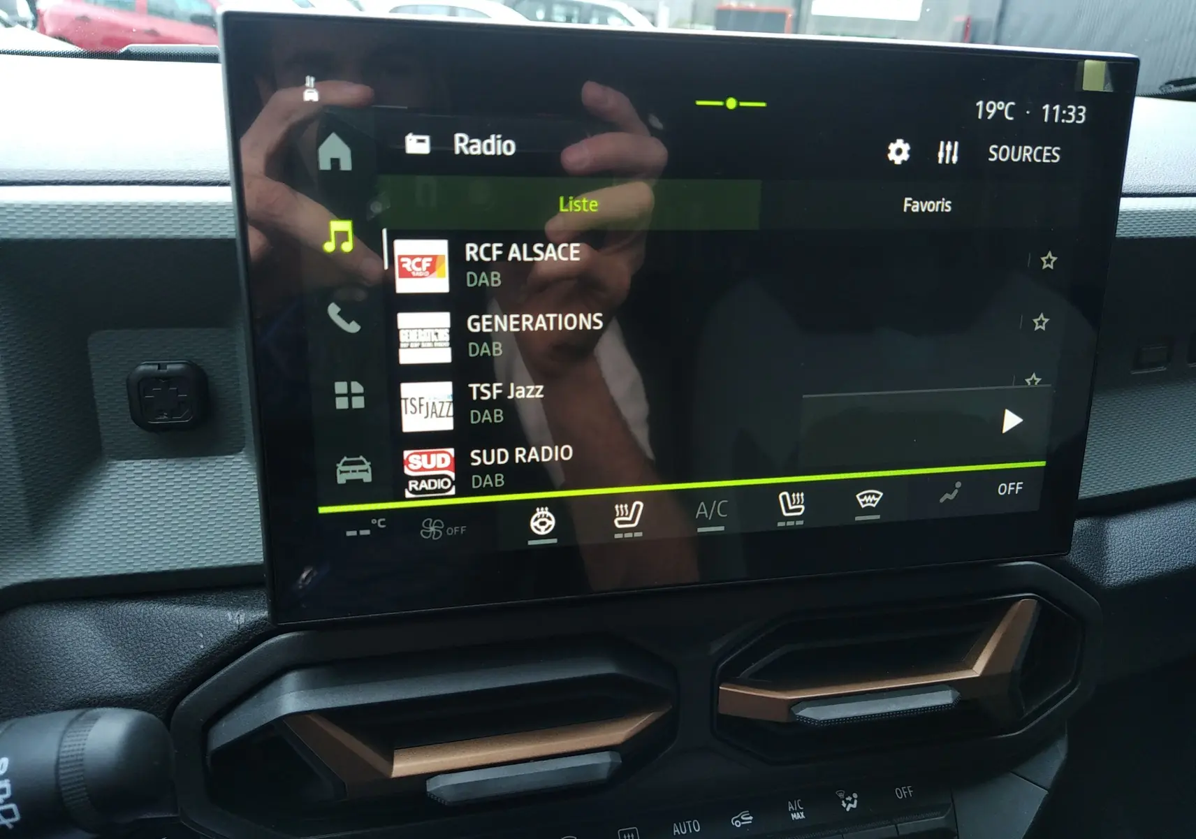 Écran tactile central affichant les radios DAB dans l’habitacle du Dacia Duster Hybrid-G couleur Sandstone.