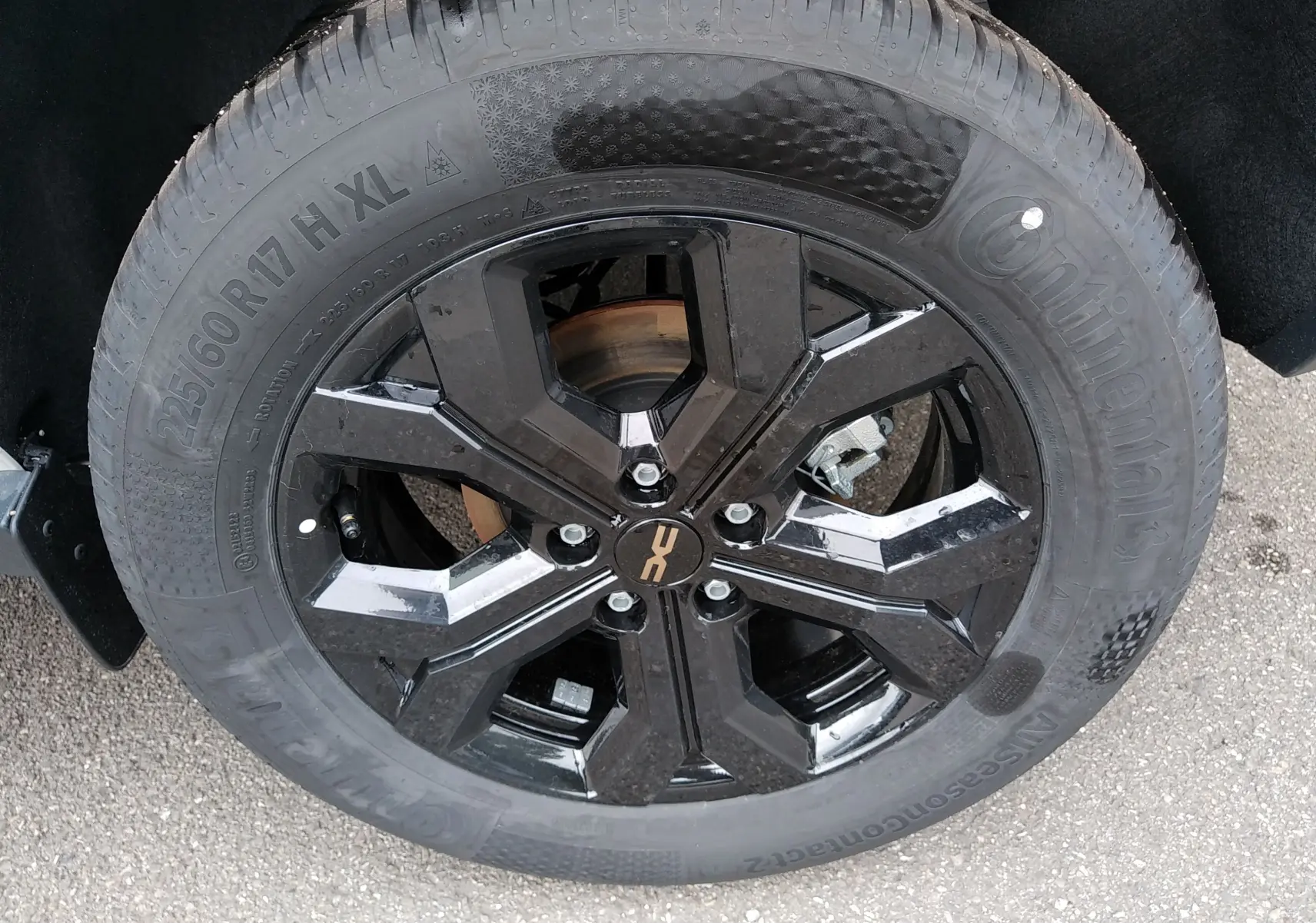 Gros plan sur la roue noire brillante du Dacia Duster Hybrid-G 150 ch, pneu Continental 225/60 R17, détail du jante moderne.