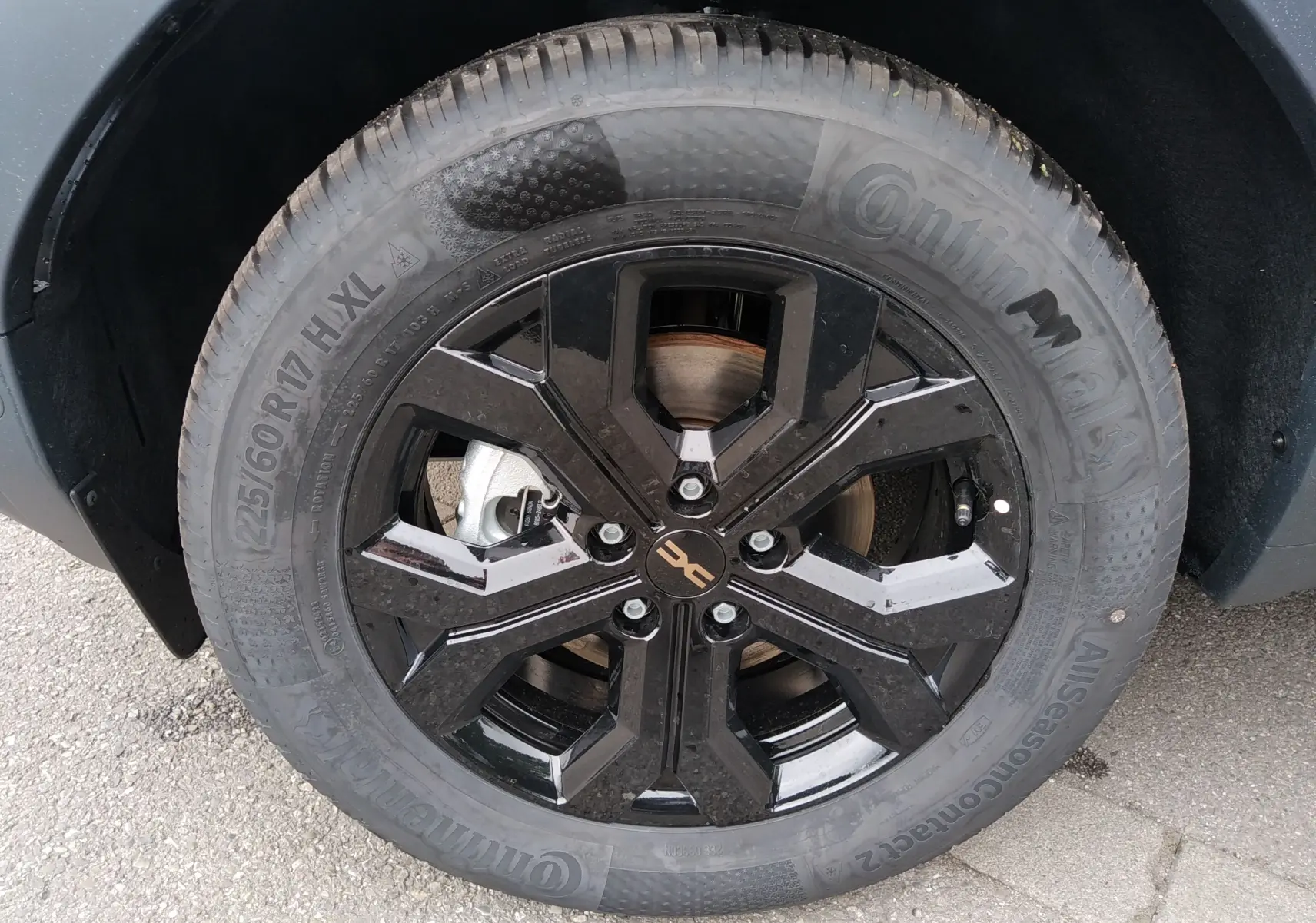 Gros plan sur la roue avant droite du Dacia Duster Hybrid-G 150 ch, jante noire brillante avec logo Dacia central.