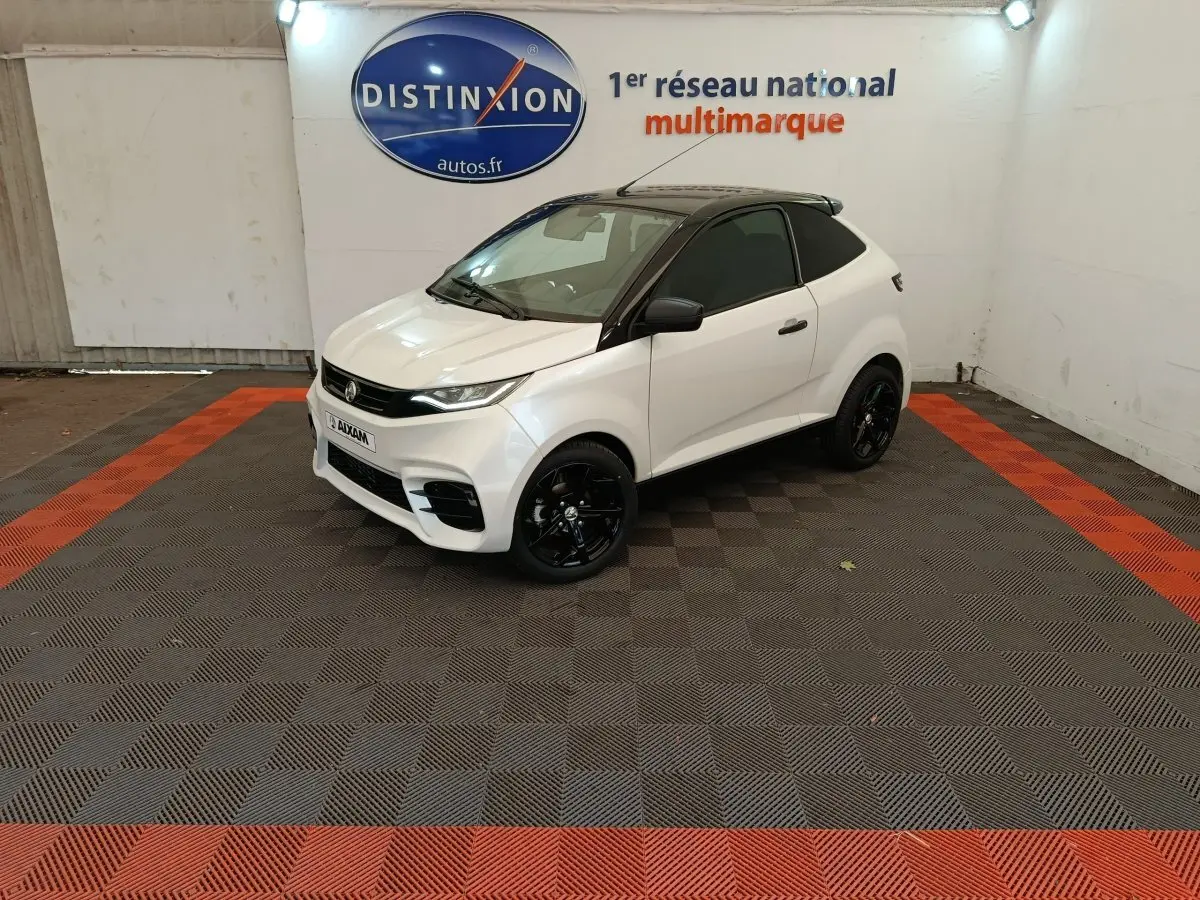Vue 3/4 avant droite d'une Aixam Ambition 0.5 City Coupe Sport blanche avec toit noir et jantes noires.