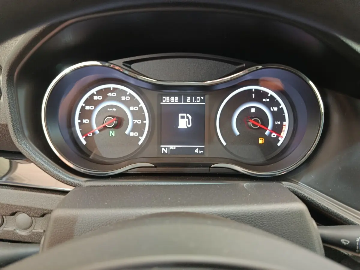 Vue rapprochée du tableau de bord de l'AIXAM AMBITION 0.5 City Coupe Sport montrant les compteurs et l'alerte de carburant.