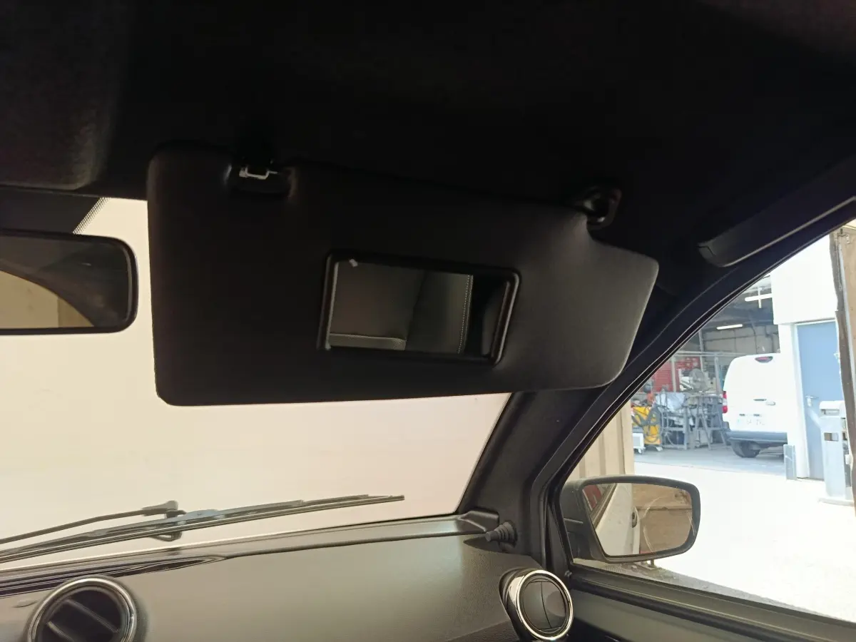 Vue intérieure côté conducteur de l'AIXAM AMBITION 0.5 City Coupe Sport 2026, montrant le pare-soleil et le rétroviseur extérieur.