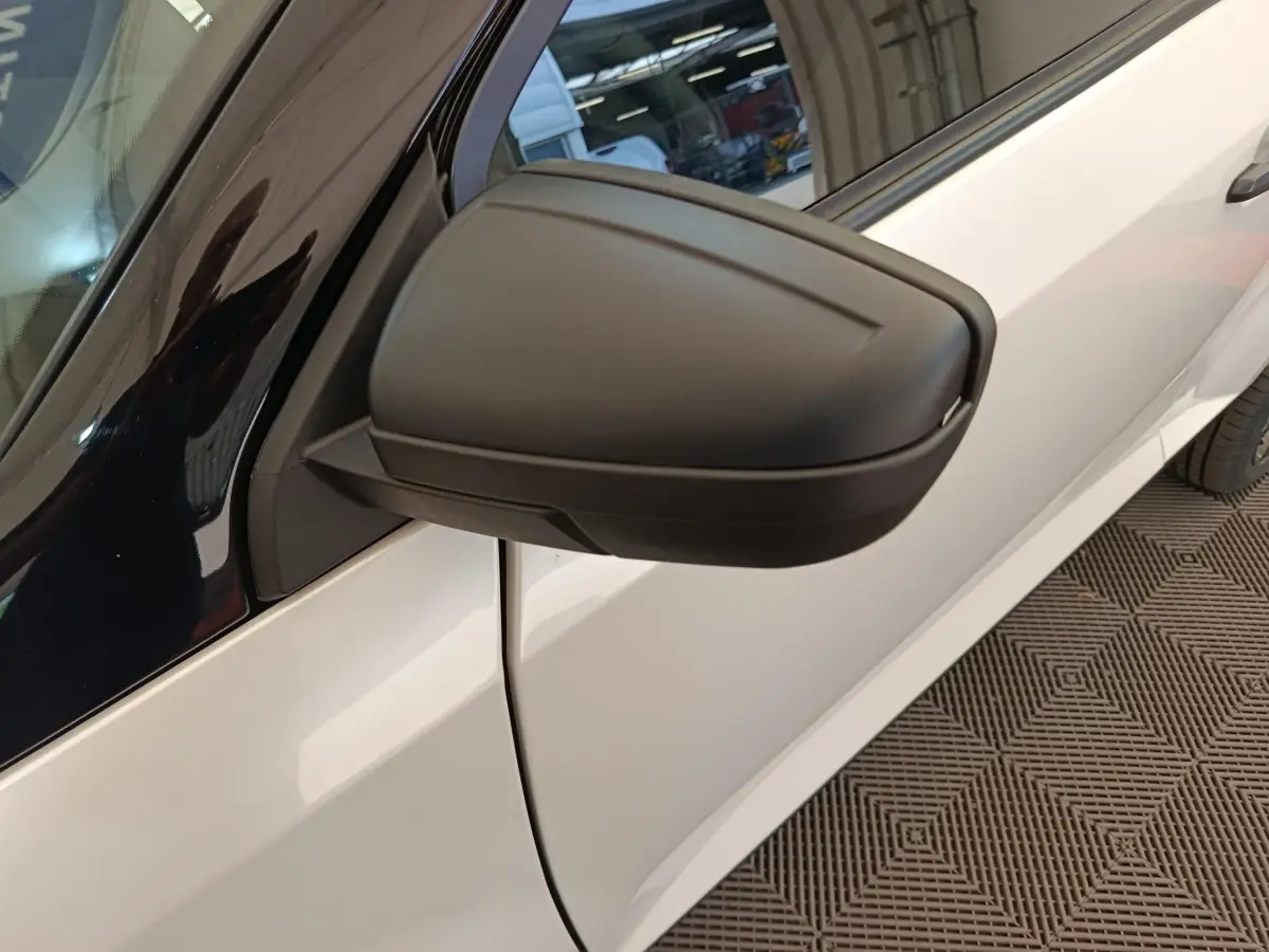Gros plan sur le rétroviseur extérieur côté conducteur d’une Aixam Ambition 0.5 City Coupe Sport blanc.