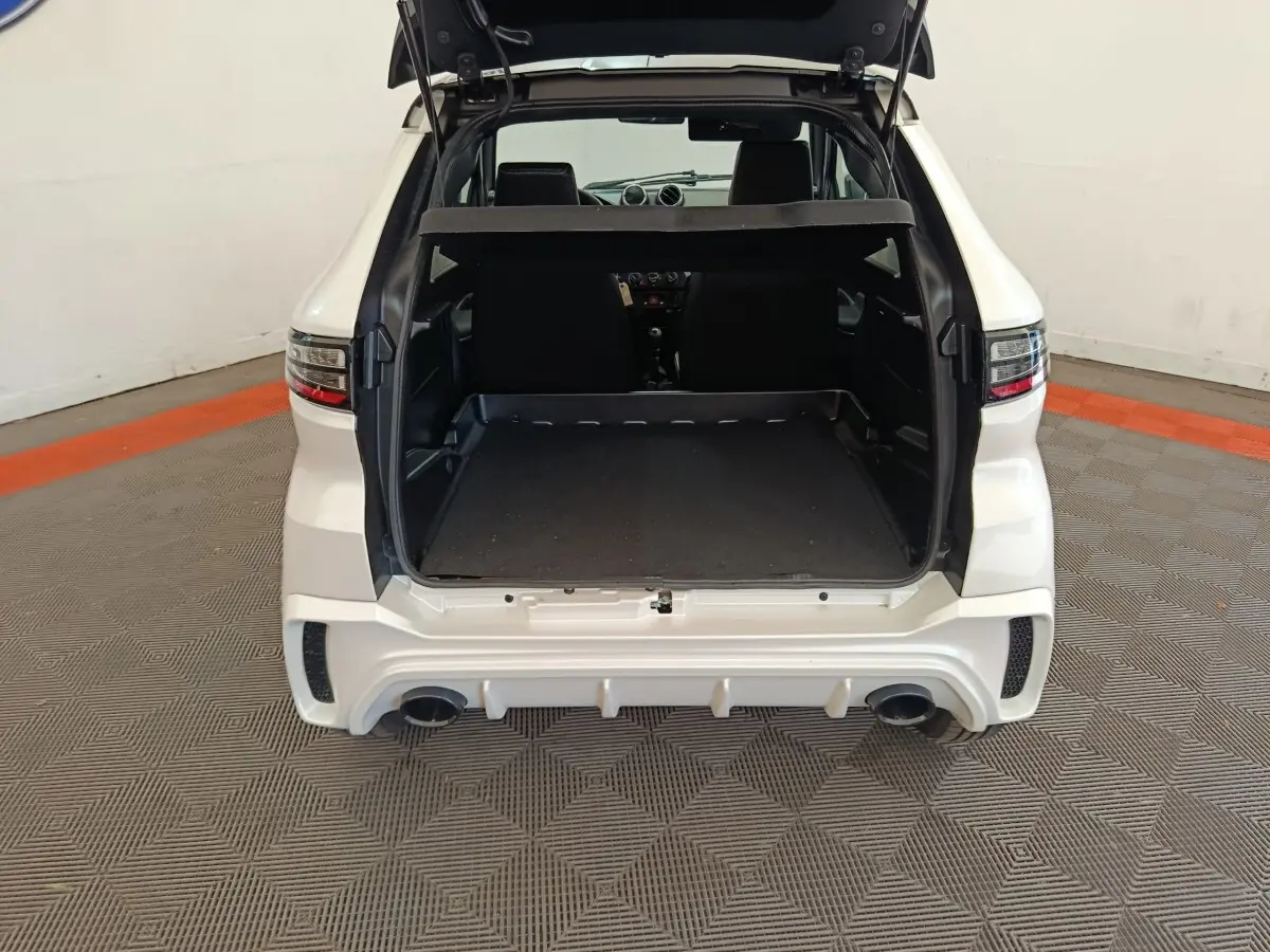 Vue arrière ouverte de l'AIXAM Ambition 0.5 City Coupe Sport blanc, coffre spacieux et double sortie d'échappement visible.