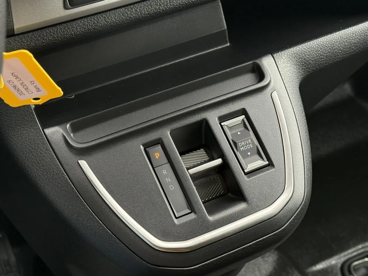 Gros plan sur la console centrale noire du Citroën Jumpy blanc Icy, mettant en valeur la commande de boîte automatique et le bouton Drive Mode.