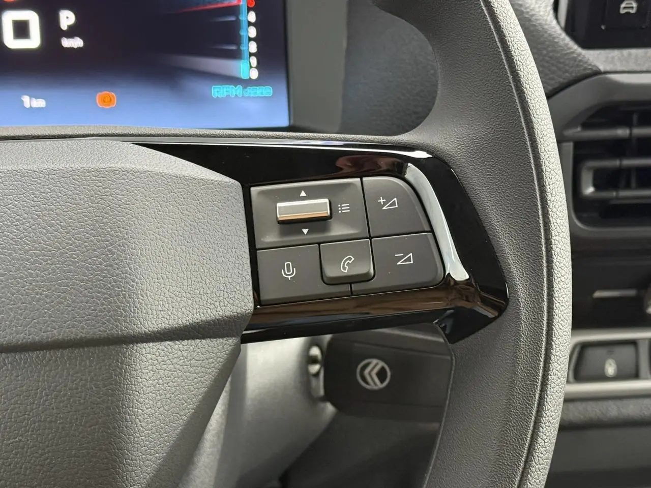 Gros plan sur les commandes au volant du Citroën Jumpy 2026, avec tableau de bord numérique en arrière-plan.