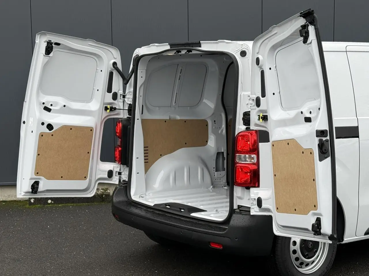 Vue arrière du Citroën Jumpy blanc icy avec portes battantes ouvertes dévoilant l’espace de chargement vide et protégé.