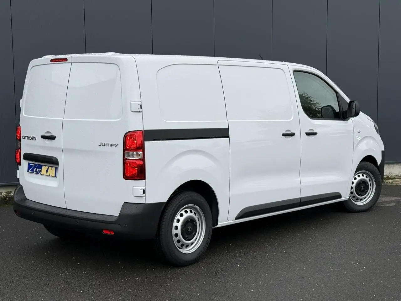 Vue 3/4 arrière droite du Citroën Jumpy blanc Icy, fourgon avec porte latérale coulissante et feux arrière rouges.