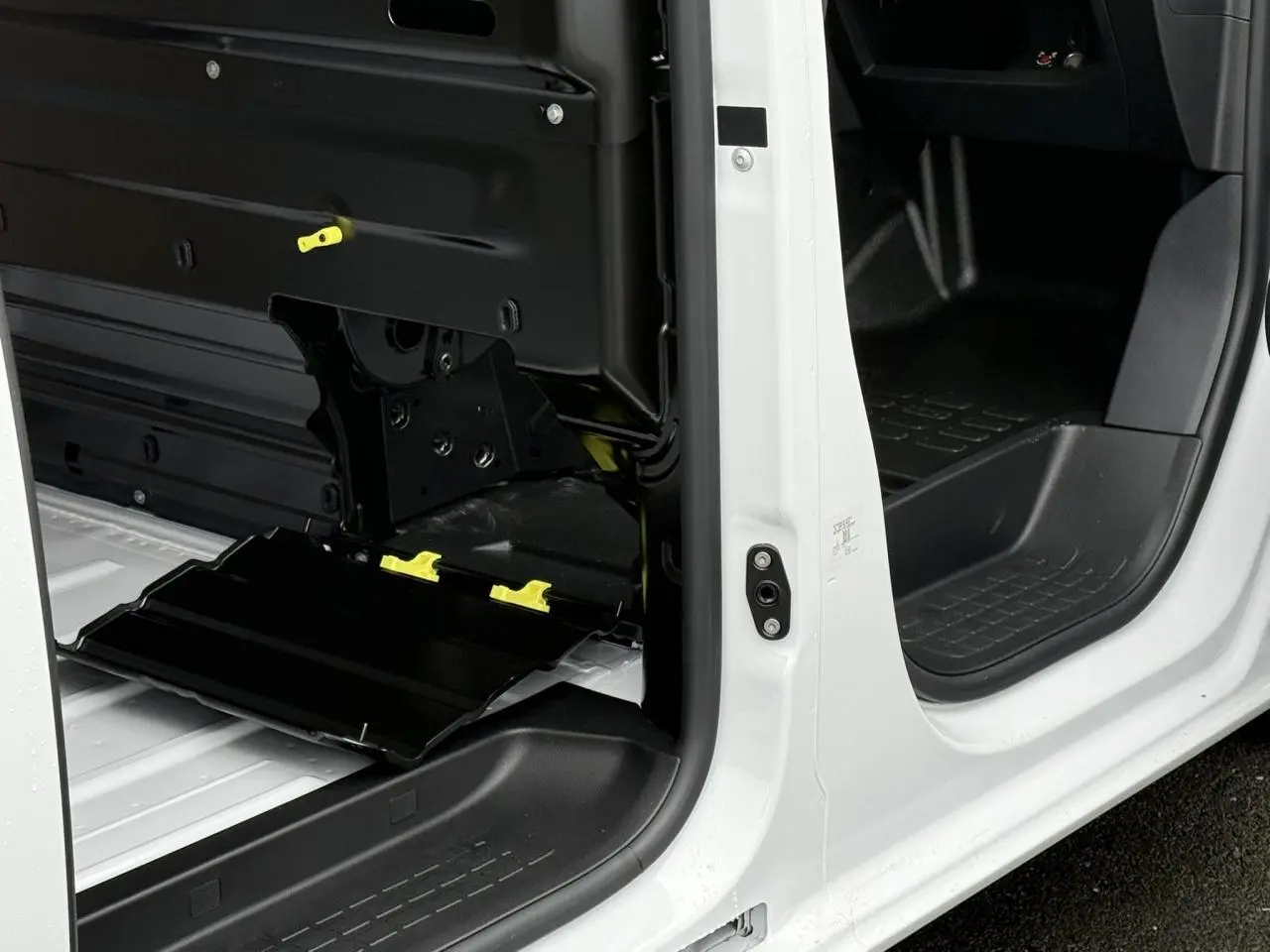 Vue rapprochée des portes latérales ouvertes du Citroën Jumpy blanc Icy, montrant l’intérieur utilitaire et les mécanismes de la porte.