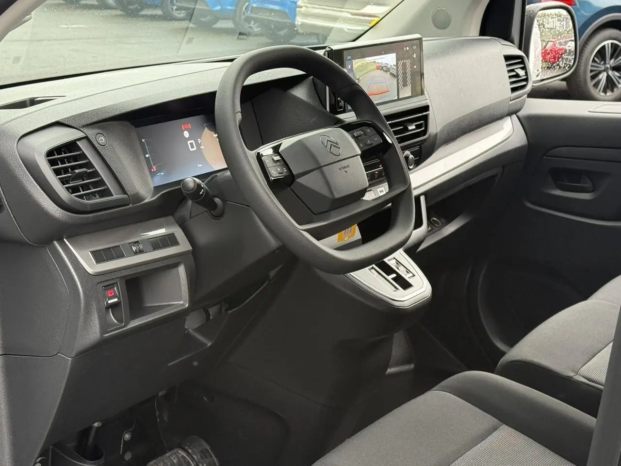Vue intérieure côté conducteur du Citroën Jumpy 2026 avec tableau de bord noir et écran tactile affichant la caméra de recul.