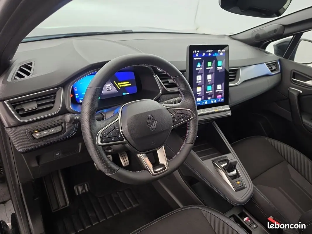 Vue intérieure côté conducteur du Renault Symbioz bleu 2025, volant multifonctions et grand écran tactile vertical au centre.