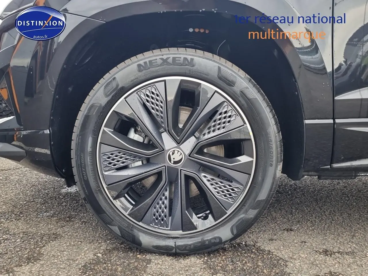 Gros plan sur la roue avant gauche noire avec jante alu au design moderne du Skoda Karoq 1.5 TSI 150 Sportline 2025.