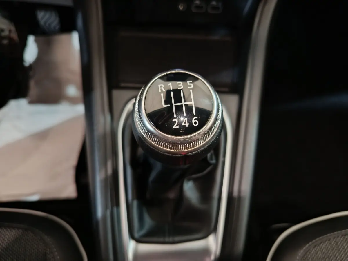 Gros plan sur le levier de vitesse manuel noir du Renault Captur rouge 2024, version techno TCe 90.