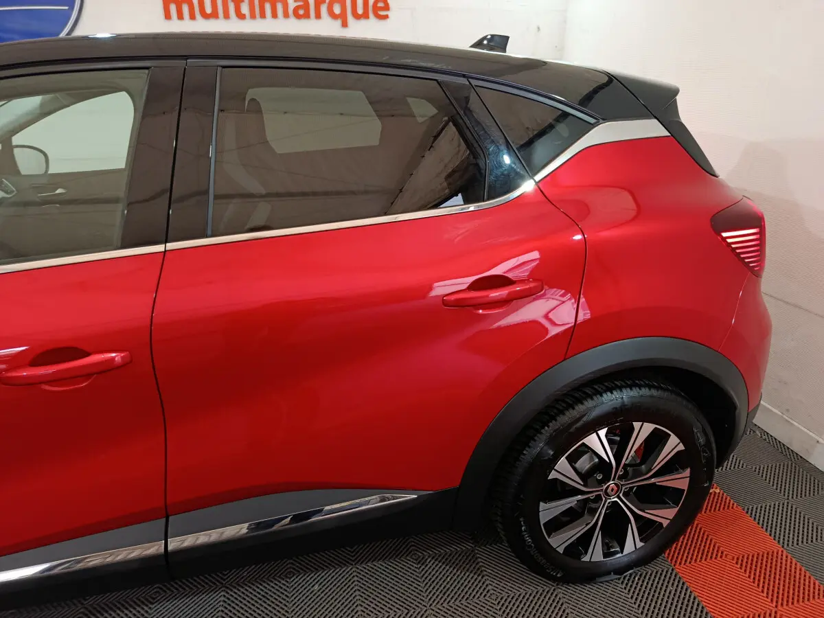 Profil arrière droit du Renault Captur rouge 2024 avec toit noir et jantes alliage bicolores.