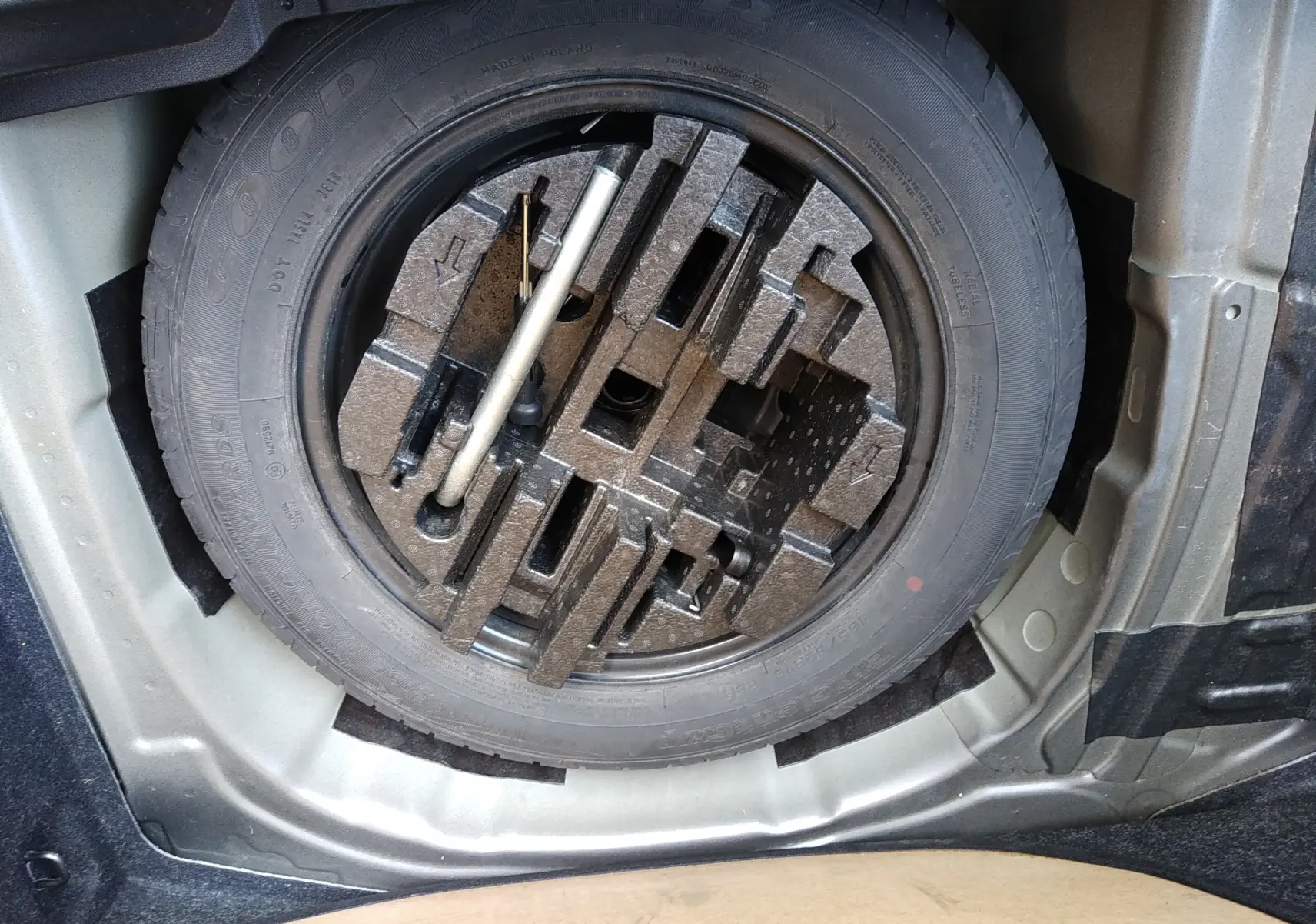 Gros plan sur la roue de secours et les outils de bord du coffre d'une Skoda Kamiq gris 2023, version essence.