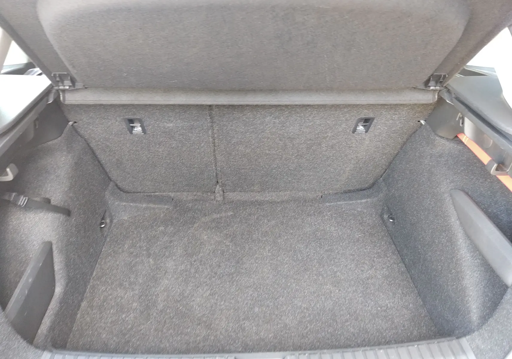 Coffre ouvert du Skoda Kamiq gris 2023, vue intérieure montrant l’espace de chargement tapissé de tissu gris.