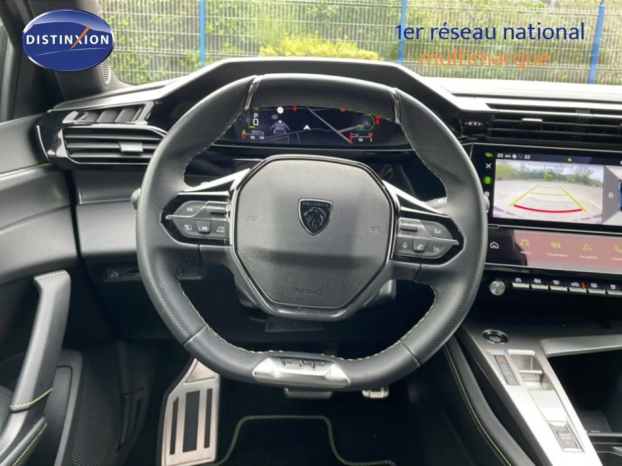 Vue intérieure centrée sur le volant cuir noir et le tableau de bord numérique du Peugeot 408 1.2 Hybrid 2025.