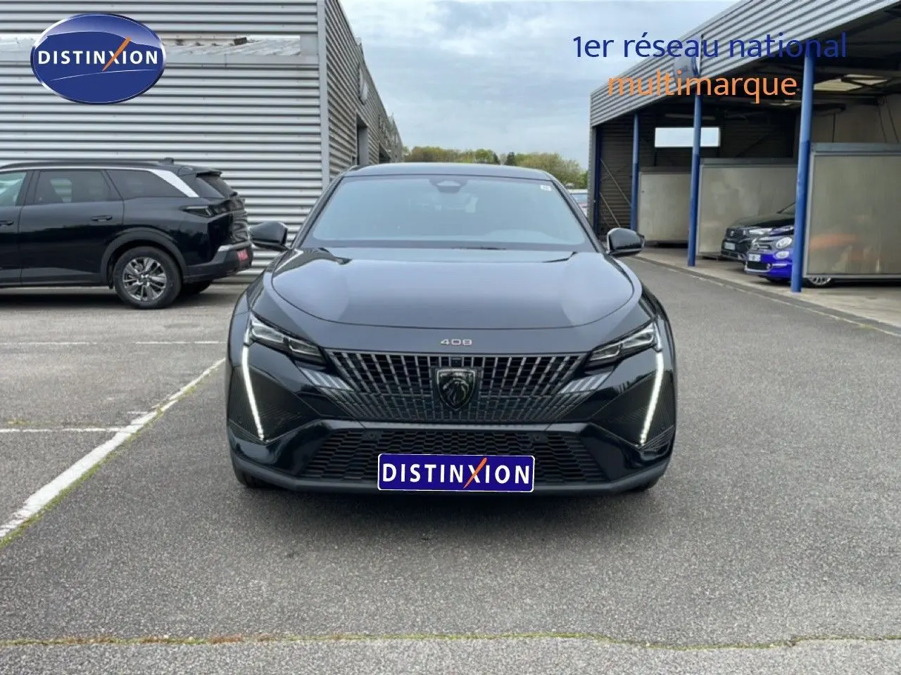 Vue frontale d'une Peugeot 408 1.2 Hybrid 145ch GT noire métallisée avec feux LED distinctifs allumés.