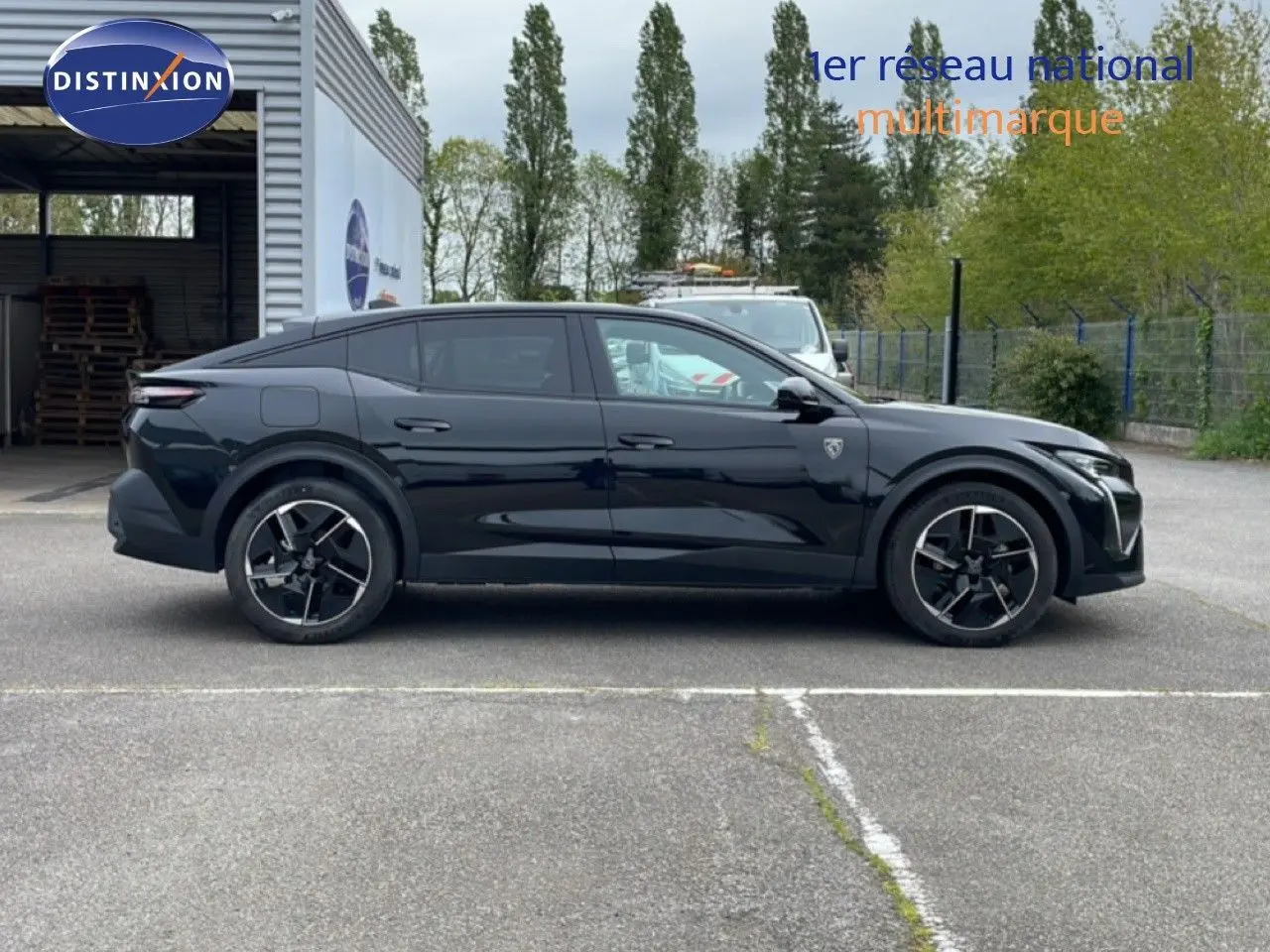 Profil droit d'une Peugeot 408 noire métal 2025, version hybride, avec jantes noires et détails sportifs visibles.