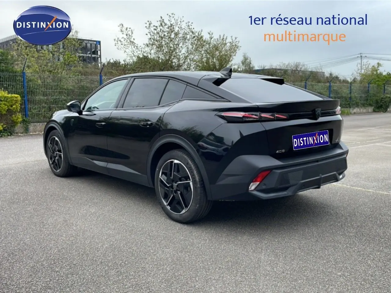 Peugeot 408 noir métal en 3/4 arrière droit, soulignant ses lignes fluides et ses feux arrière LED distinctifs.