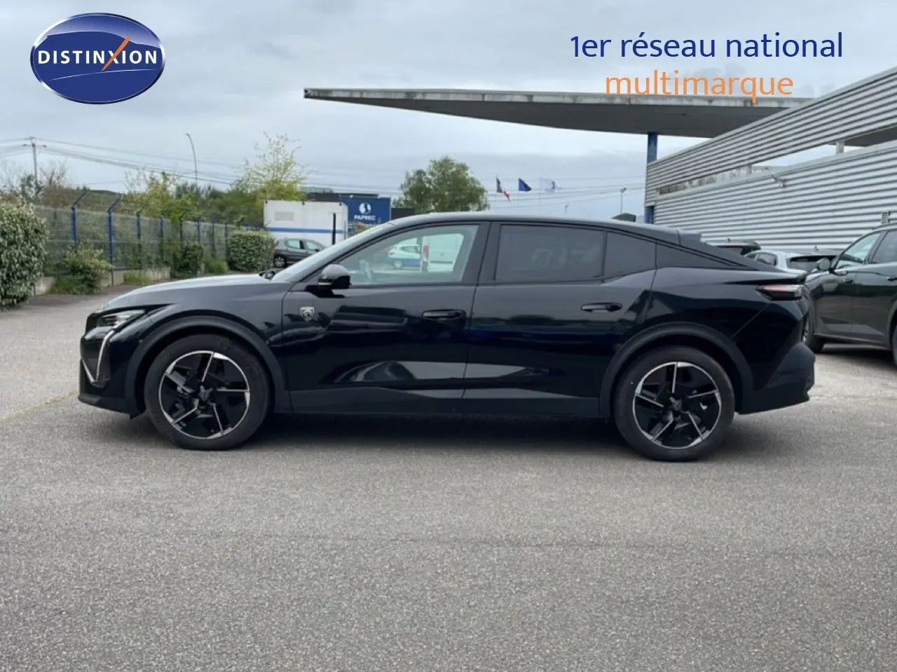 Profil côté gauche de la Peugeot 408 noire métal 2025, soulignant ses lignes fluides et ses jantes noires distinctives.