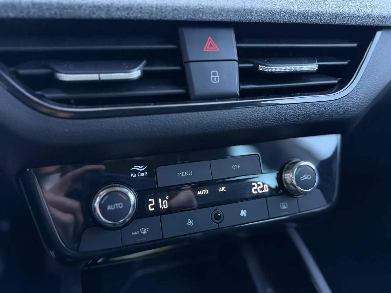 Gros plan sur la console centrale du Skoda Scala TSI 116, affichant la climatisation automatique bi-zone avec réglages numériques.