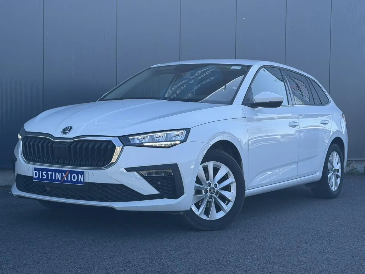 Vue 3/4 avant gauche d'une Skoda Scala blanc glacier avec calandre noire et jantes alliage 16 pouces.