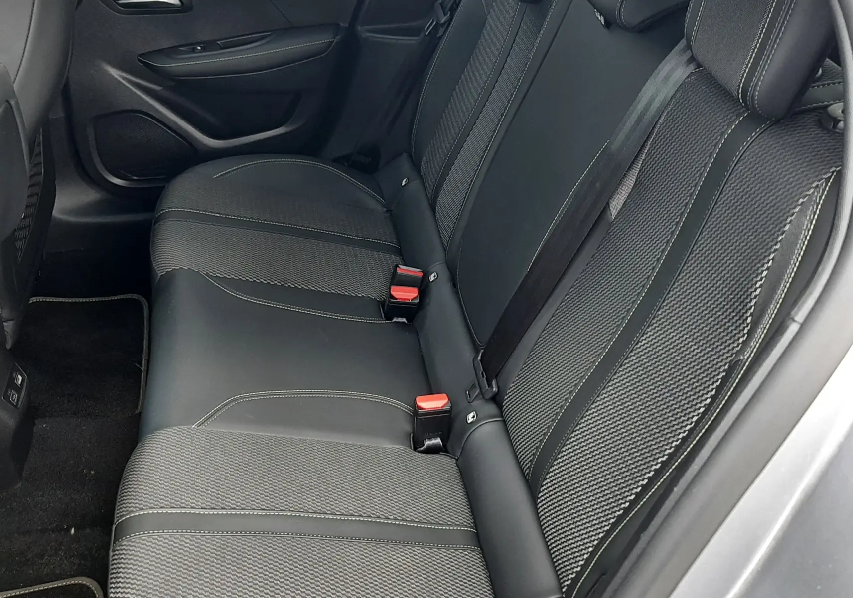 Vue intérieure côté gauche des sièges arrière en tissu et cuir noir de la Peugeot 208 1.2 100CH GT gris Artense 2025.