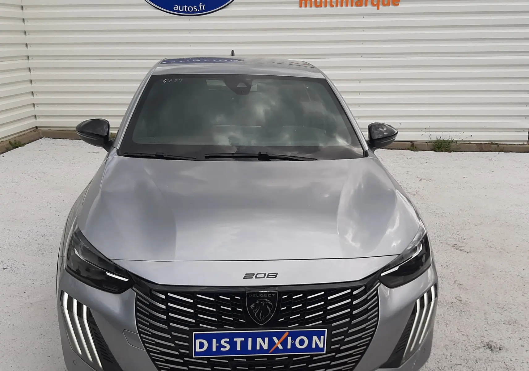 Vue avant d'une Peugeot 208 1.2 100CH GT gris Artense avec calandre noire et feux LED distinctifs.