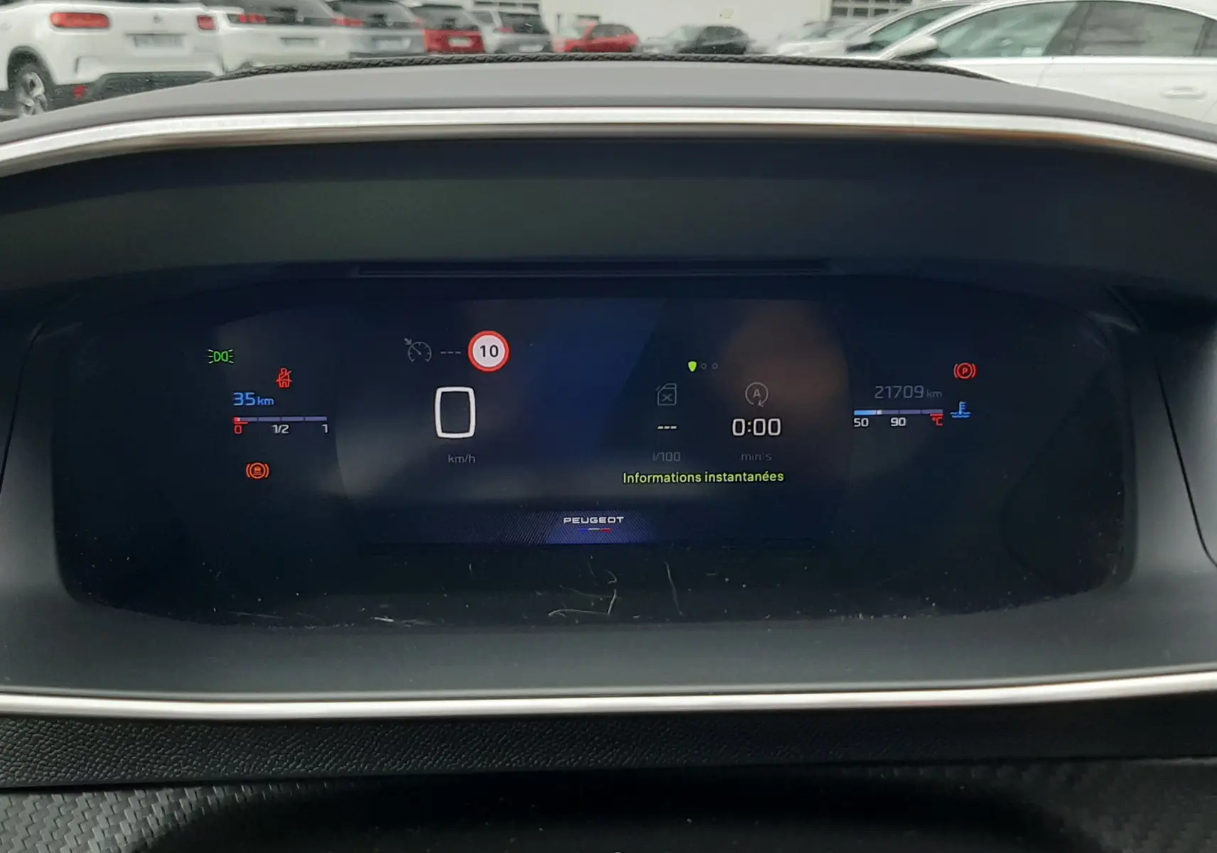 Tableau de bord numérique de la Peugeot 208 gris Artense, affichant la vitesse à 0 km/h et les informations instantanées.