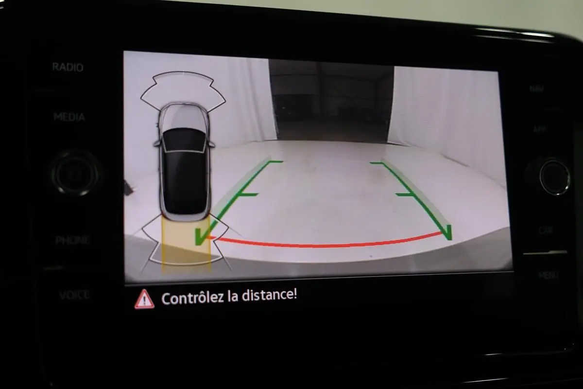 Écran de caméra de recul du Volkswagen T-Roc Cabriolet montrant l'arrière avec lignes de guidage vertes et rouges.