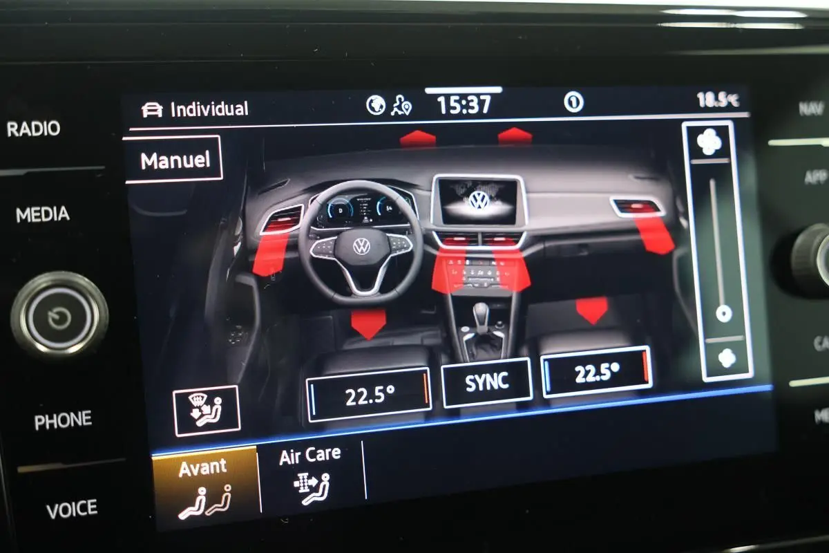 Vue intérieure du tableau de bord du Volkswagen T-Roc Cabriolet 2025 avec affichage digital et commandes climatisation.