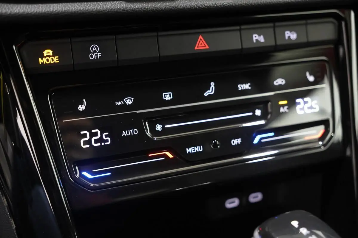 Détail du tableau de bord du Volkswagen T-Roc Cabriolet beige, affichant la climatisation digitale à 22,5°C.