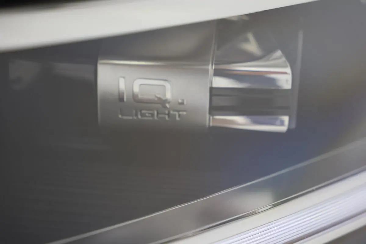Gros plan sur le détail lumineux IQ.Light du Volkswagen T-Roc Cabriolet beige métallisé, mettant en valeur la technologie LED.