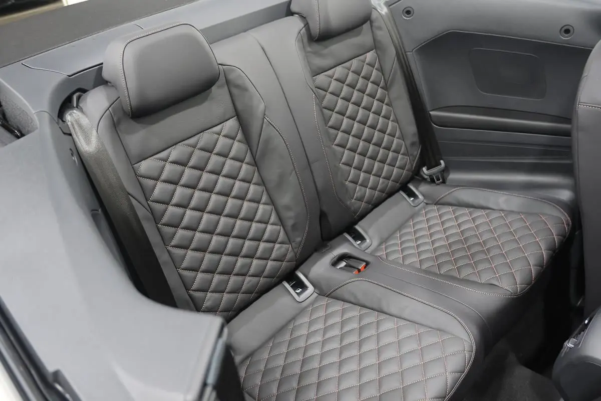 Vue rapprochée des sièges arrière en cuir noir matelassé du Volkswagen T-Roc Cabriolet beige métallisé 2025.